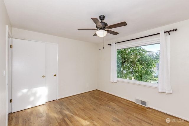 unfurnished bedroom with a closet, light hardwood / wood-style flooring, and ceiling fan