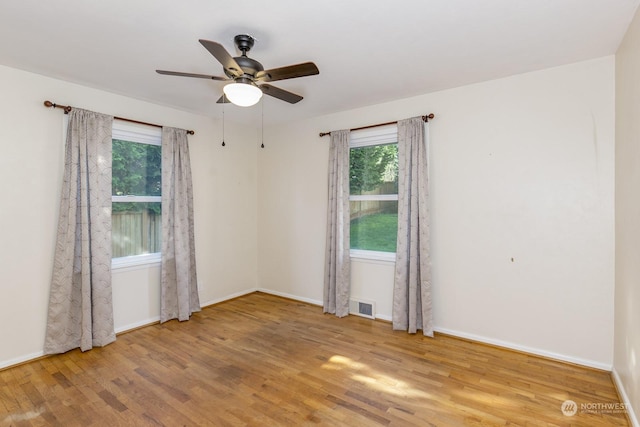 unfurnished room featuring plenty of natural light, ceiling fan, and light hardwood / wood-style flooring