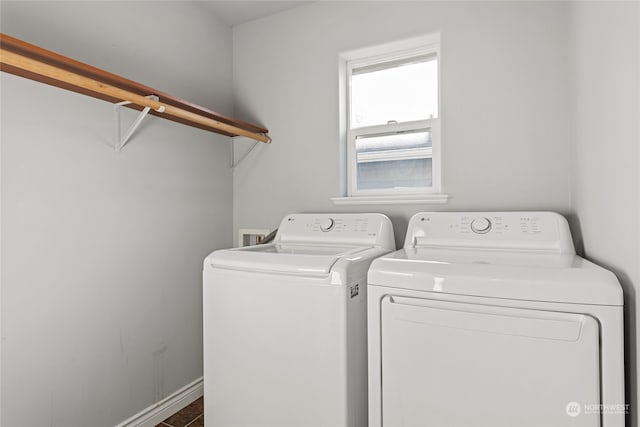 washroom featuring separate washer and dryer and dark tile patterned floors