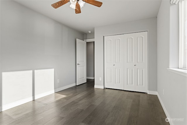 unfurnished bedroom with ceiling fan, dark wood-type flooring, and a closet