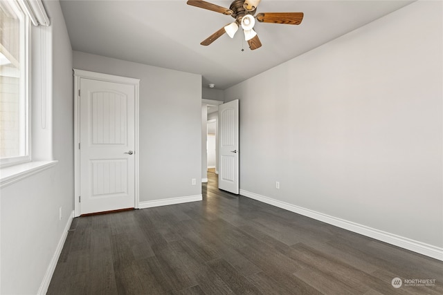 unfurnished bedroom with ceiling fan and dark wood-type flooring