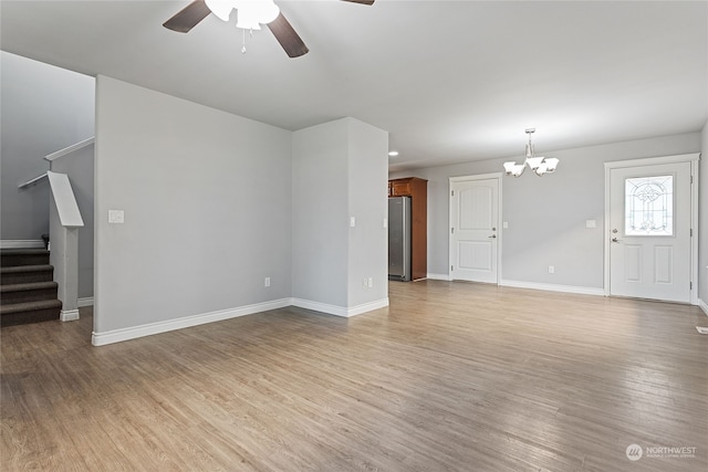 unfurnished living room featuring light wood-type flooring and ceiling fan with notable chandelier