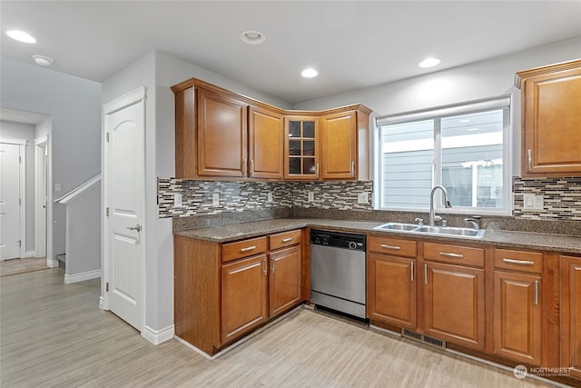 kitchen with sink, backsplash, stainless steel dishwasher, and light hardwood / wood-style floors