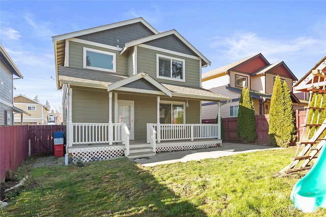 view of front of property featuring covered porch, a playground, and a front lawn