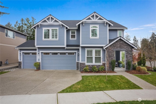 craftsman house with a garage and a front lawn