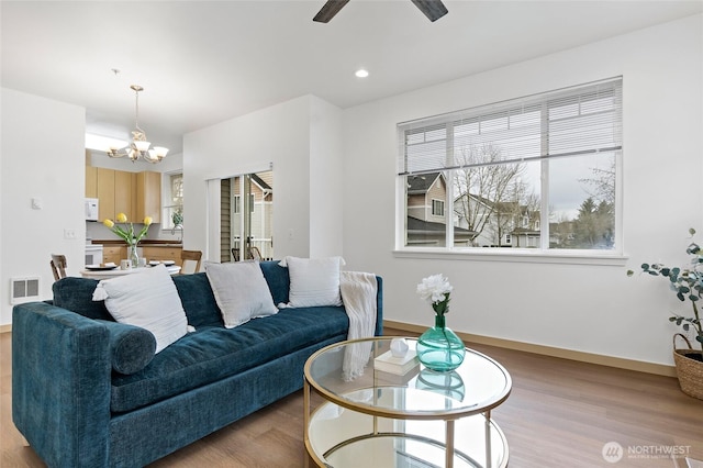 living area with visible vents, recessed lighting, ceiling fan with notable chandelier, and wood finished floors