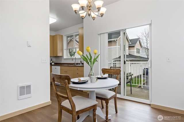 dining area with visible vents, baseboards, wood finished floors, and a chandelier