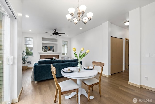 dining area featuring recessed lighting, baseboards, wood finished floors, and a fireplace