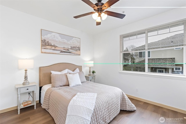 bedroom with ceiling fan, baseboards, and wood finished floors