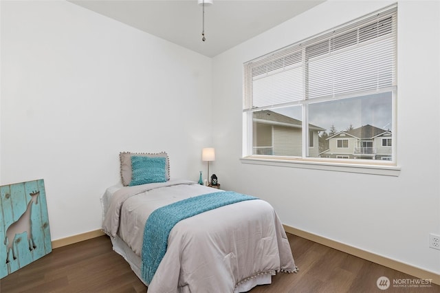 bedroom with baseboards and wood finished floors