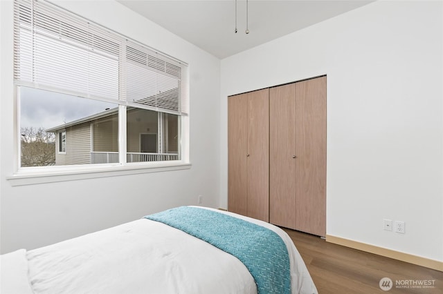 bedroom featuring a closet, baseboards, and wood finished floors