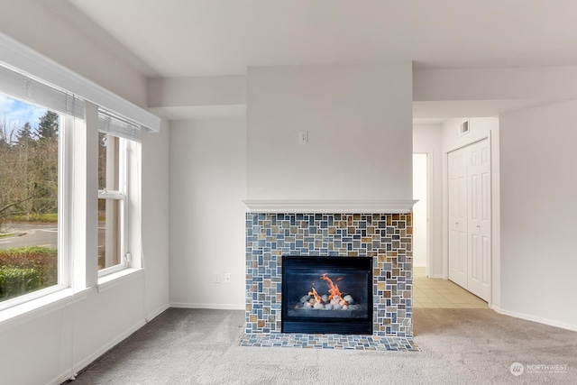 unfurnished living room featuring light colored carpet and a fireplace