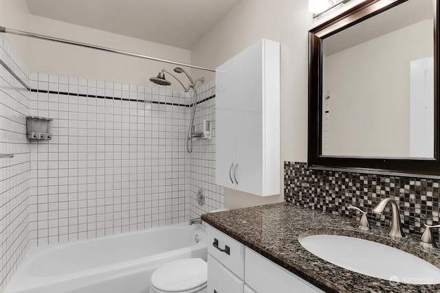 full bathroom featuring vanity, backsplash, tiled shower / bath, and toilet