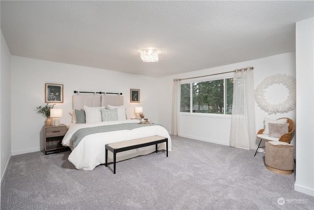 bedroom featuring a textured ceiling and carpet