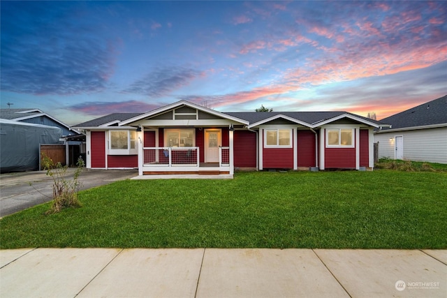 single story home with a porch and a lawn