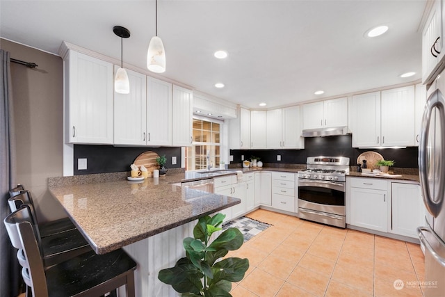 kitchen featuring kitchen peninsula, decorative light fixtures, stainless steel appliances, light tile patterned floors, and white cabinets