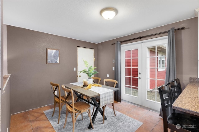 dining space featuring light tile patterned flooring and french doors