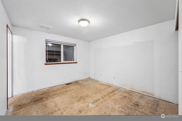 unfurnished room featuring a textured ceiling