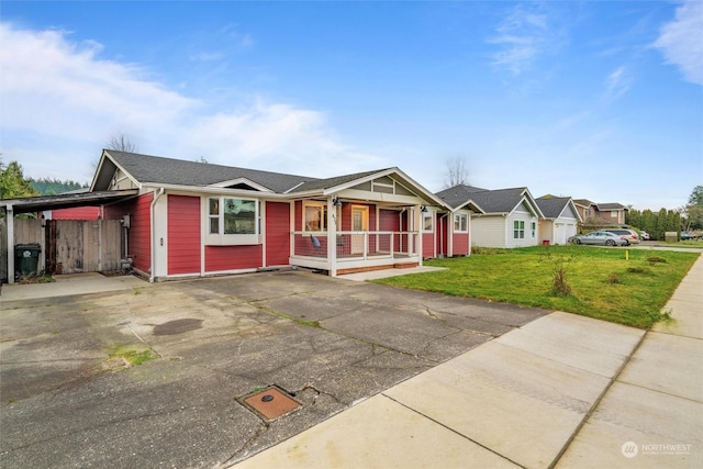 ranch-style house with a porch, a front yard, and a carport