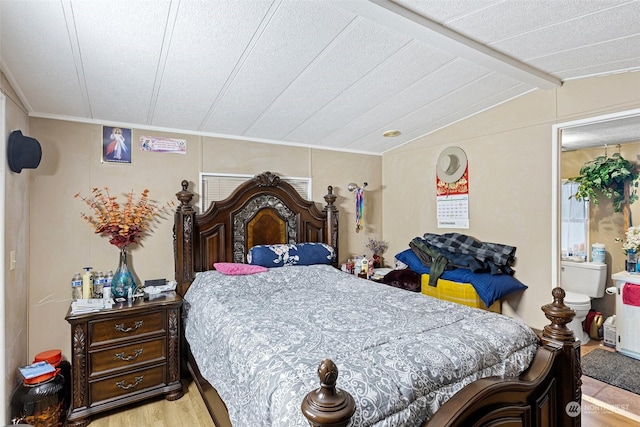 bedroom featuring light wood-type flooring and vaulted ceiling with beams