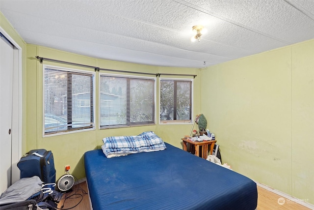 bedroom featuring a closet, wood-type flooring, and a textured ceiling