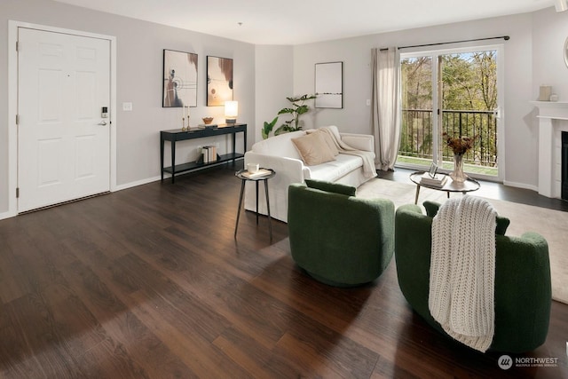 living room with dark hardwood / wood-style flooring and a tile fireplace