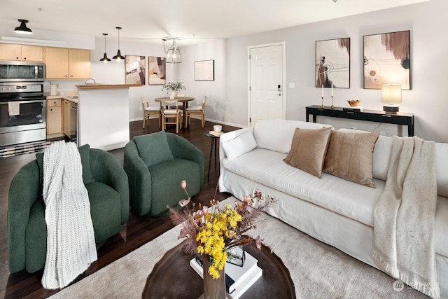 living room with dark wood-type flooring and a notable chandelier