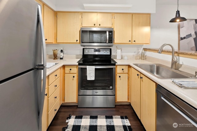 kitchen with sink, dark wood-type flooring, hanging light fixtures, light brown cabinetry, and appliances with stainless steel finishes