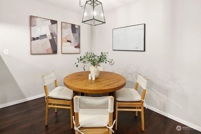 dining room with dark hardwood / wood-style flooring and a notable chandelier