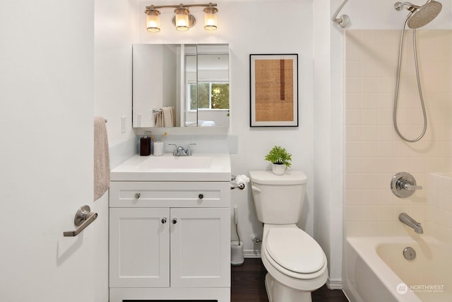 full bathroom featuring vanity, tiled shower / bath combo, and toilet