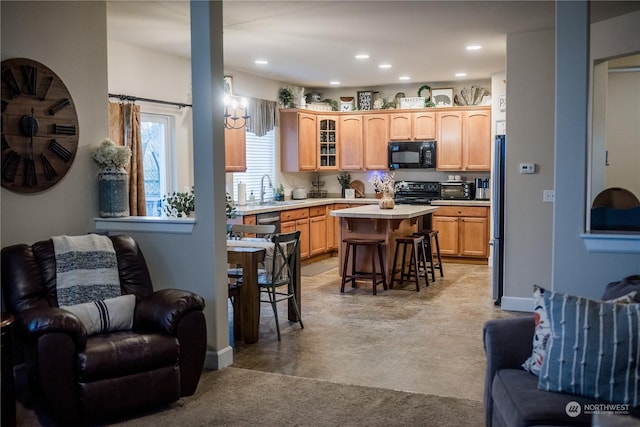 kitchen featuring a kitchen breakfast bar, a center island, light brown cabinetry, and stainless steel refrigerator