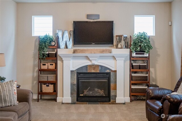 carpeted living room featuring a tiled fireplace and a healthy amount of sunlight