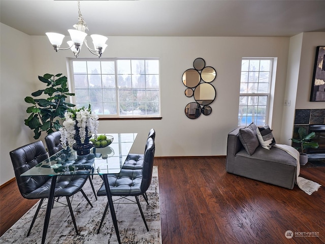 dining room with a chandelier, dark wood-type flooring, and baseboards