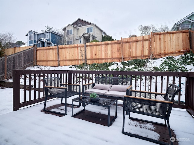 snow covered deck featuring a fenced backyard and an outdoor living space