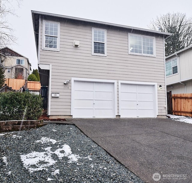 view of front of house with a garage, fence, and driveway