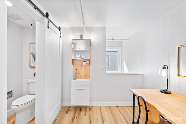 bathroom with hardwood / wood-style floors and toilet