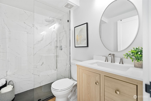 bathroom featuring vanity, toilet, and a tile shower