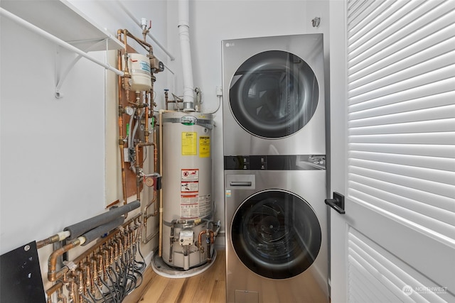 washroom with hardwood / wood-style floors, gas water heater, and stacked washer / dryer