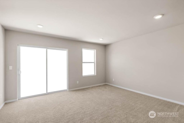 spare room featuring light colored carpet