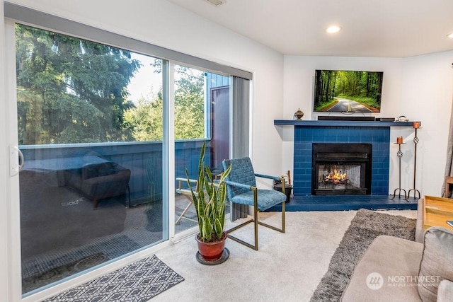 carpeted living room featuring a tile fireplace