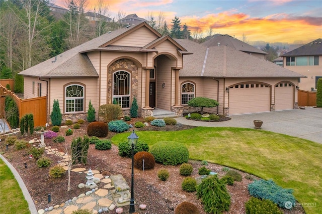 view of front of property featuring a garage and a lawn