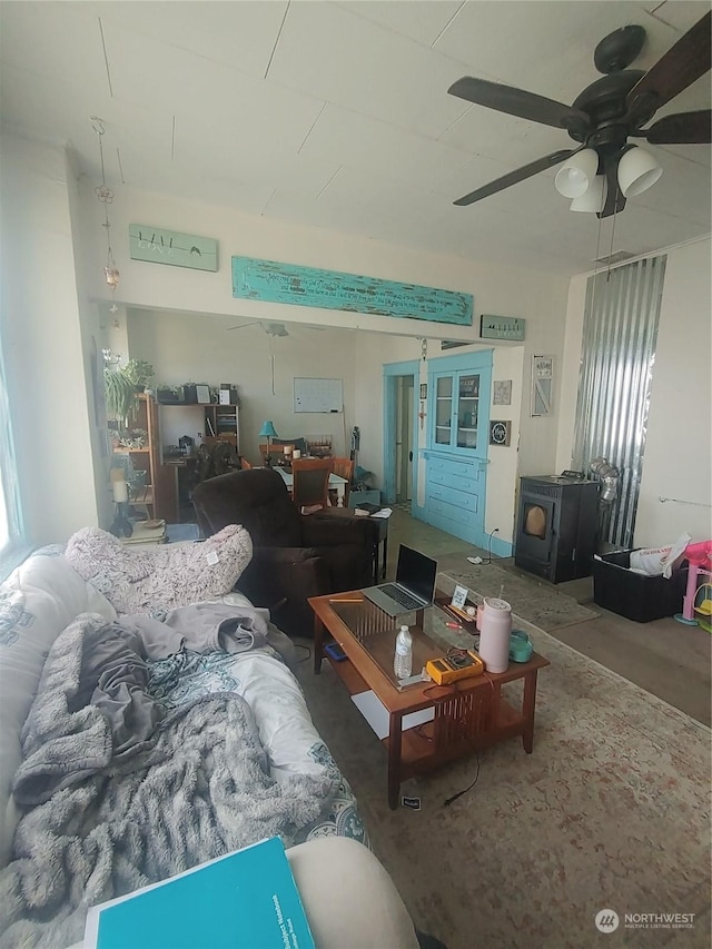 living room featuring ceiling fan and a wood stove