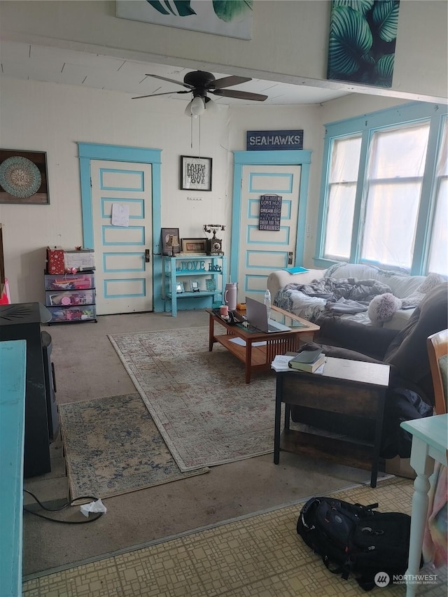 living room with ceiling fan and concrete flooring