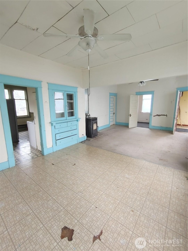 307 S Exchange St, Aberdeen, WA 98520 - spare room featuring baseboards, a ceiling fan, and a wood stove