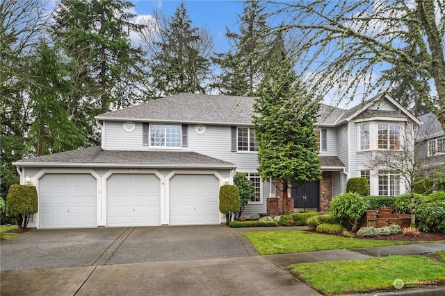 view of front of house featuring a garage and a front lawn