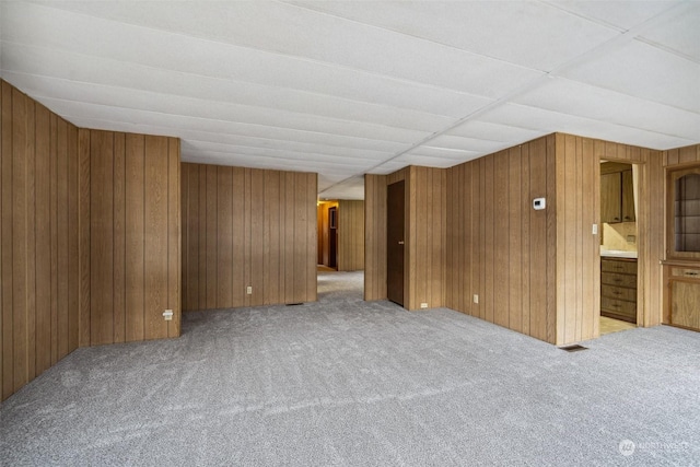 interior space with wood walls and light colored carpet