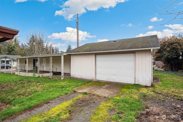 garage with a yard and a porch