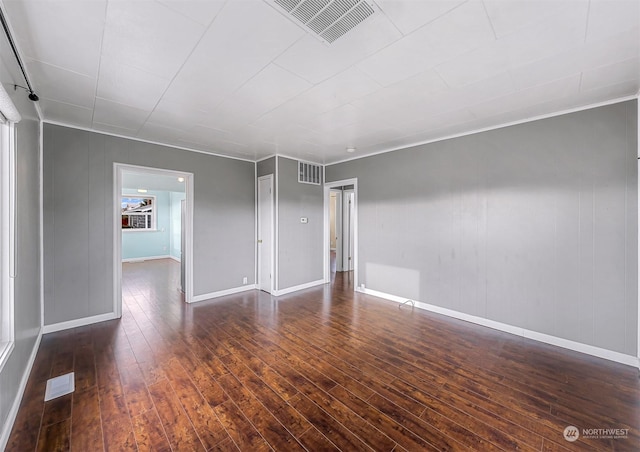 empty room with crown molding and dark hardwood / wood-style floors