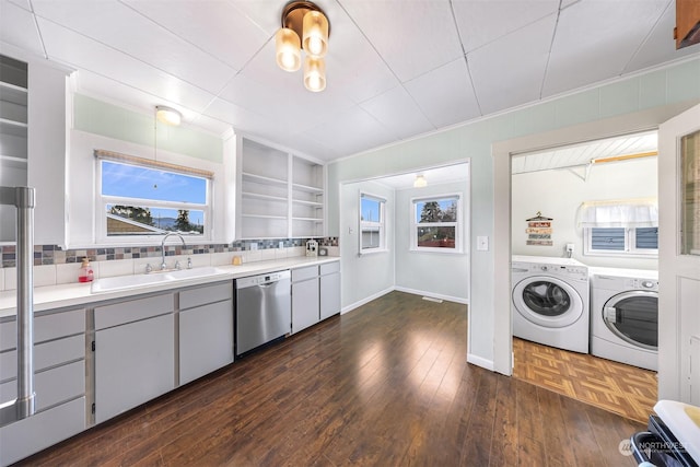 interior space featuring dishwasher, tasteful backsplash, dark hardwood / wood-style flooring, washing machine and clothes dryer, and sink