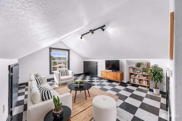 living room with a textured ceiling and vaulted ceiling